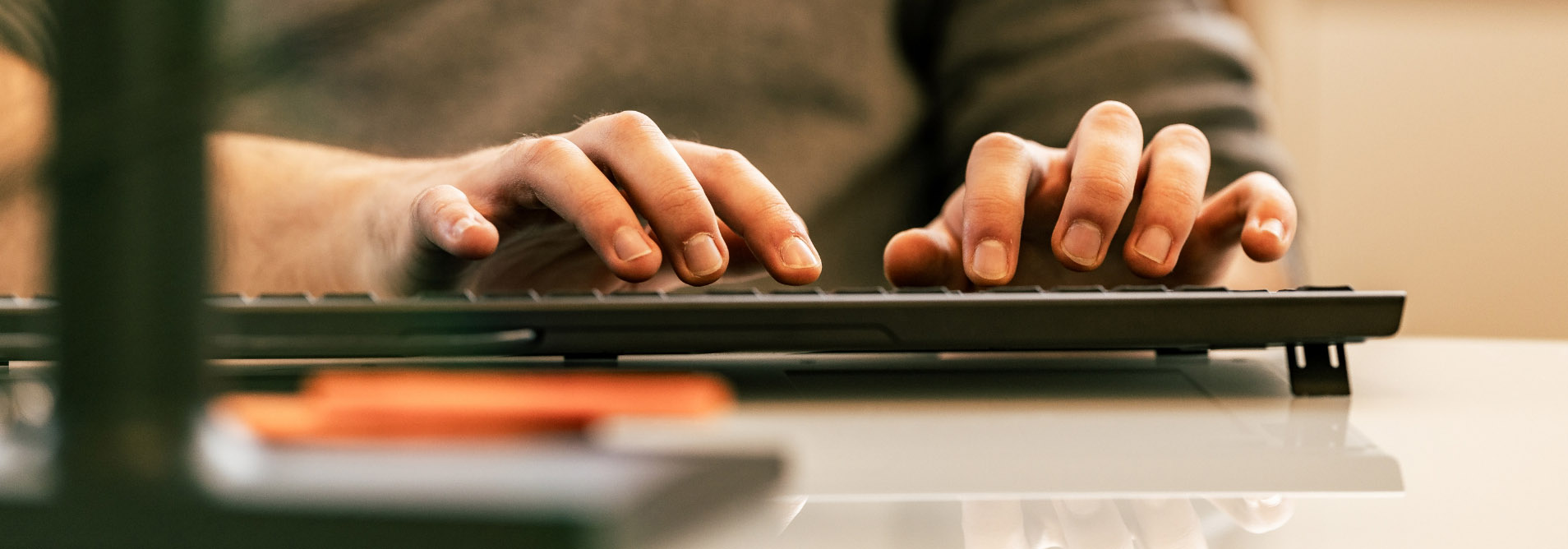 Foto der tippenden Hände eines media-service-Mitarbeiter über der Tastatur.