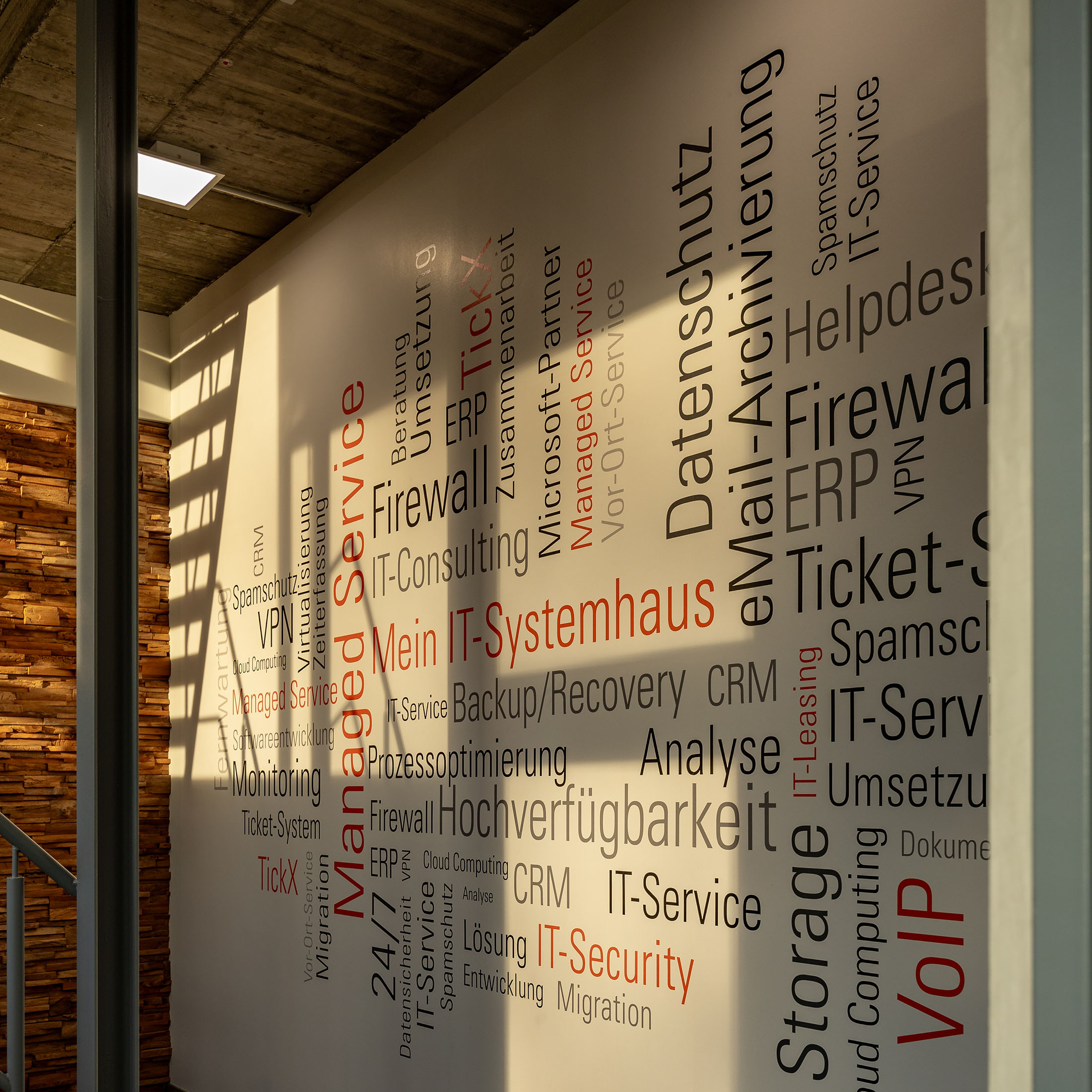 Foto einer Wand im media-service-Bürogebäude, auf der die verschiedenen Leistungen in einer großen Wortwolke zu sehen sind.