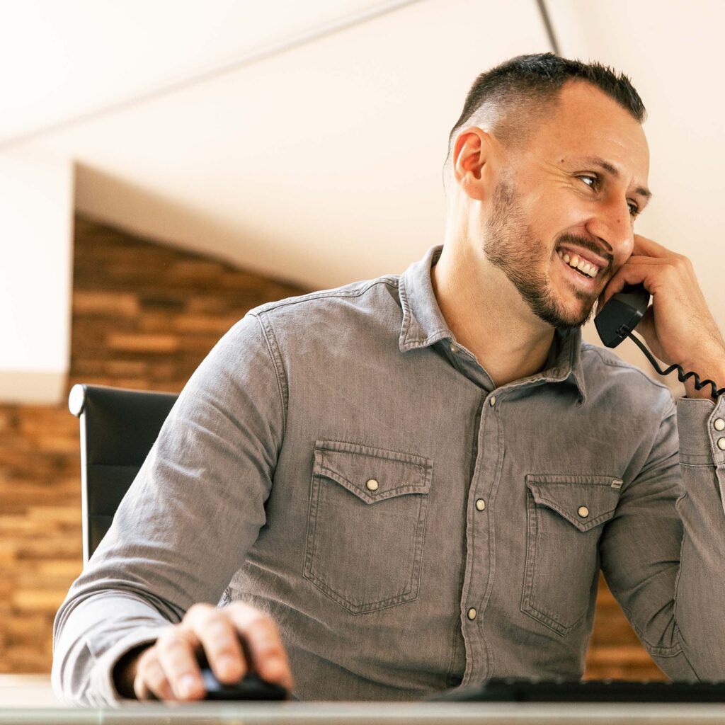 Lächelnder IT-Berater im Kundentelefonat – persönlicher Service vom Systemhaus Münster